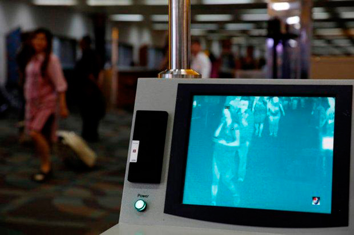 Пассажиры рейса Сингапур-Джакарта проходят через сканер "Feverscan" в аэропорту Сукарна-Хатта в Индонезии