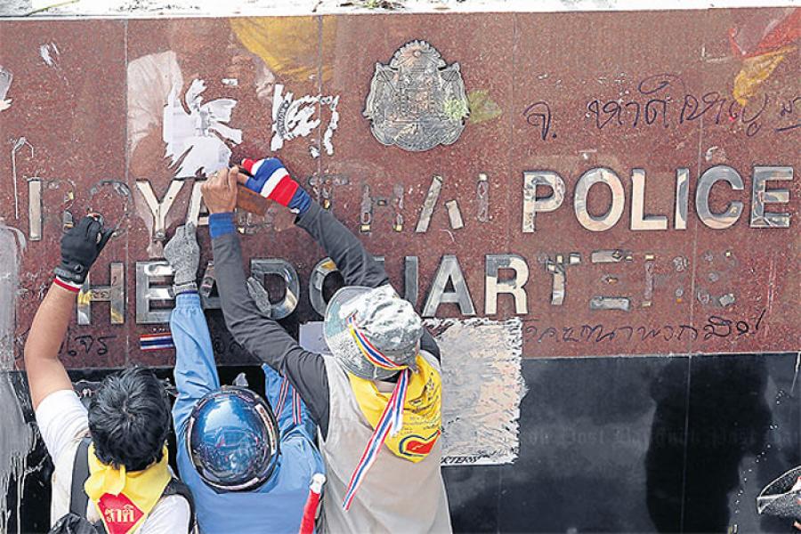 Протестующие снимают логотип Королевской полиции таиланда