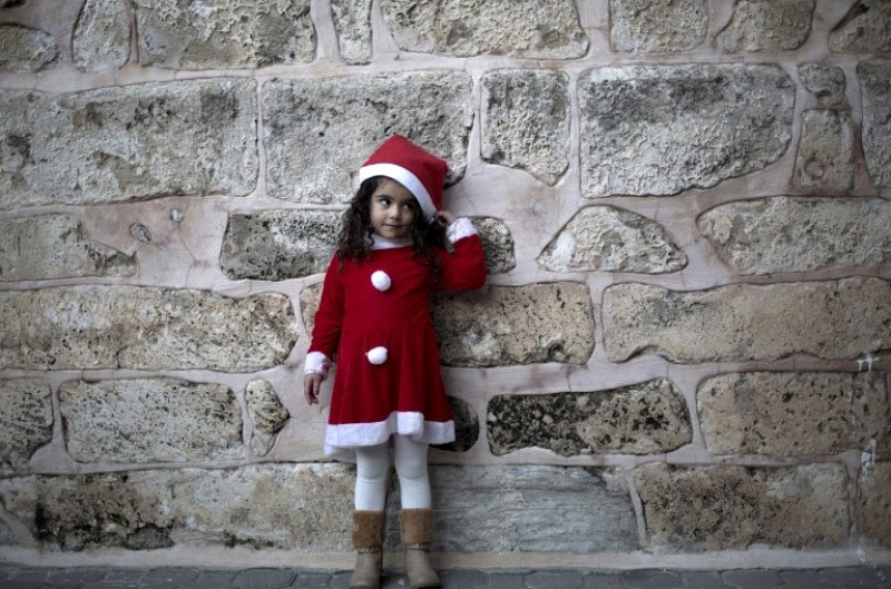 Палестина: Немножко Санты в секторе Газа. Малышка в костюме Санты у церкви: "Мы готовимся к встрече Нового года".