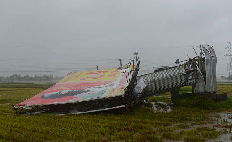 Тайфун "Доксури" сбивает рекламный щит в центральной провинции Ха Тинь 15 сентября. Фото Bloomberg/AFP, фотограф Хоан Динь Нам 