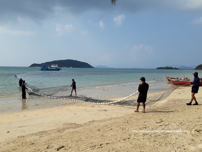 Сотрудники морского Департамента огораживают рыболовными сетями участки для купания на острове Ко Марк в провинции Трат. Фото Thai PBS