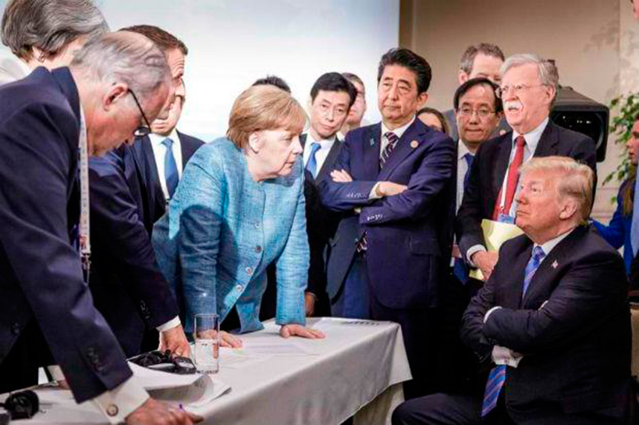Президент США Дональд Трамп беседует с канцлером Германии Ангелой Меркель в окружении других лидеров «большой семерки» во время встречи Саммит G7 в Ла-Мальби, Квебек, Канада. Фото, опубликованное в Twitter 9 июня пресс-секретарем Правительства Германии Штеффеном Зейбертом в субботу и снятое фотографом германского правительства Йеско Денцелем. Фото AFP.