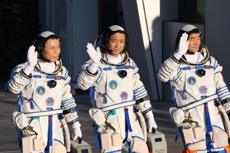 Китайские астронавты - в центре Нэ Хайшэн, командир полета, и двое членов экипажа Лю Бомин справа и Тан Хунбо слева