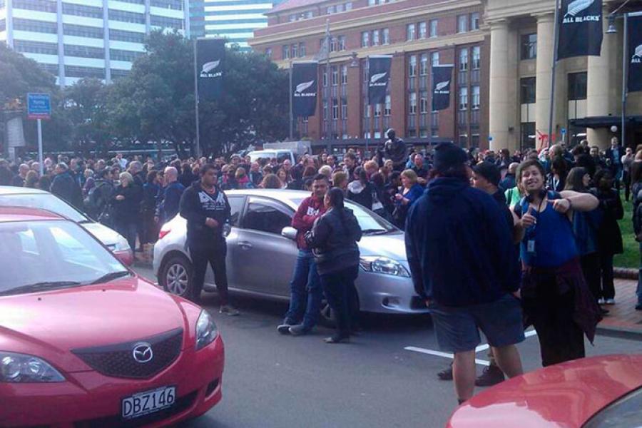 Люди вышли на улицу из здания железнодорожного вокзала в Веллингтоне, Новая Зеландия, после землетрясения. 